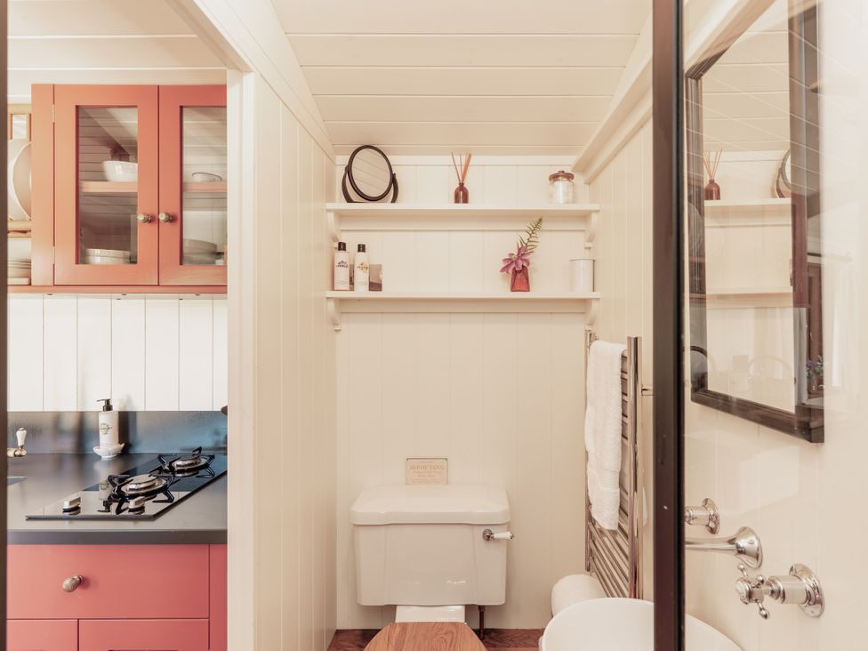 A bathroom with shelves and sink at Spindleberry Hut in Piddletrenthide