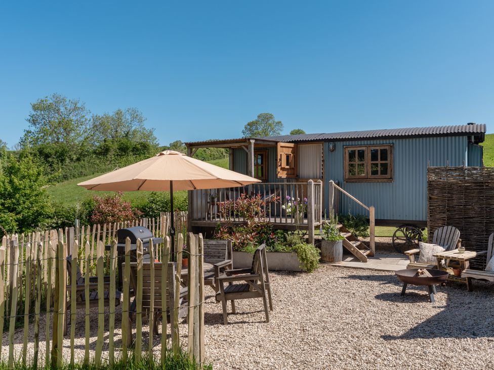An outdoor seating area with furniture and an umbrella at Spindleberry Hut Piddletrenthide