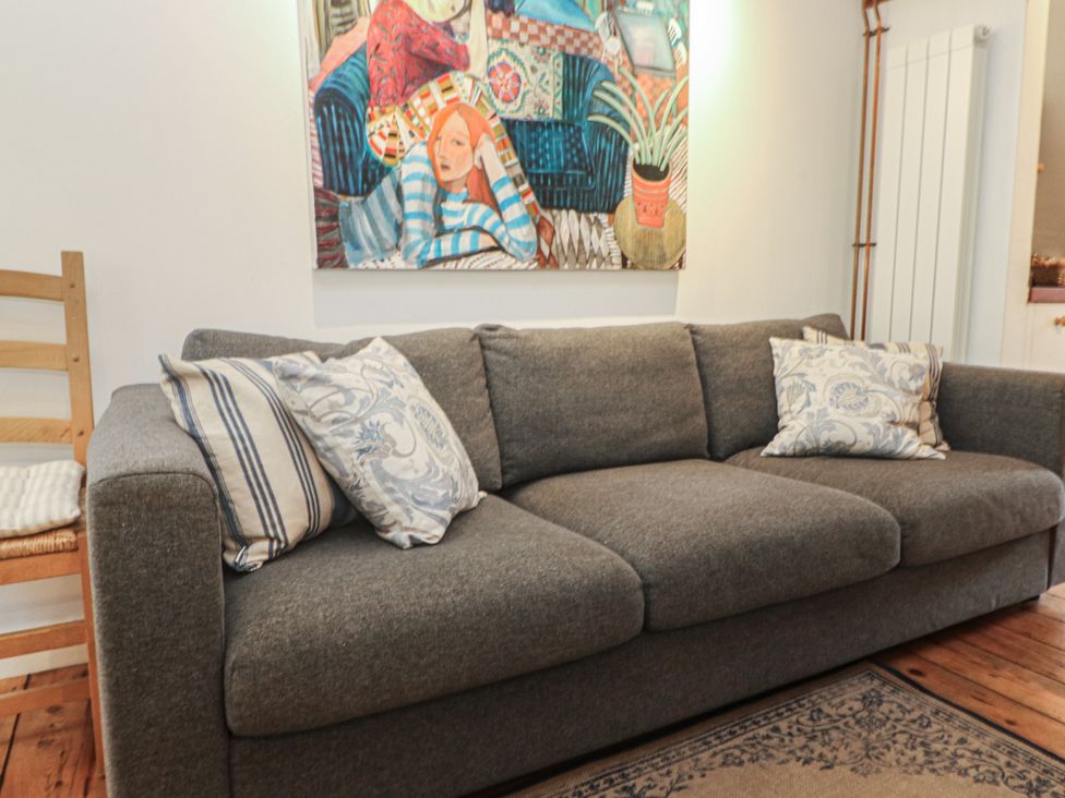 A living room with a sofa and wall art at Bodillys Cottage Newlyn
