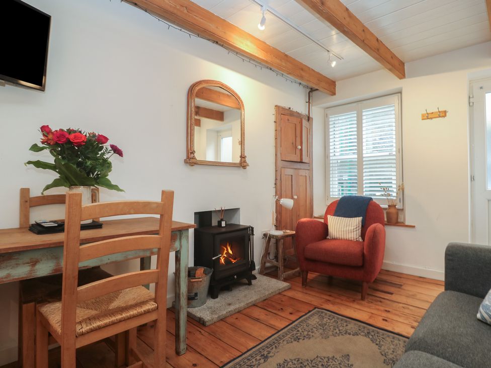 A living room with a fireplace and furniture at Bodillys Cottage in Newlyn