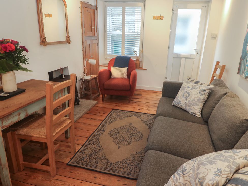 A living room with a sofa and a table at Bodillys Cottage Newlyn