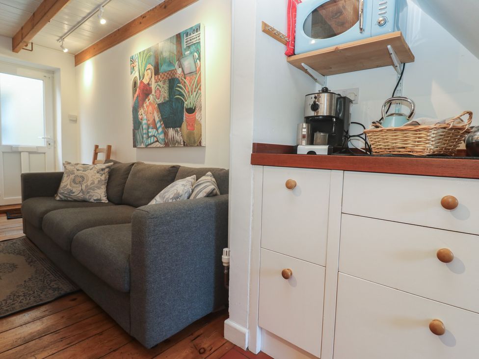 A living room with a sofa and coffee machine at Bodillys Cottage in Newlyn