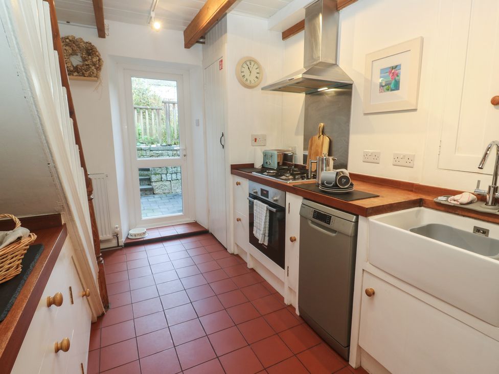 A kitchen with appliances and a door at Bodillys Cottage in Newlyn