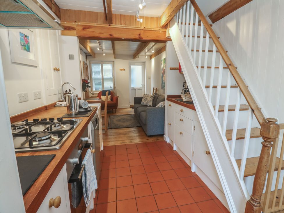 A kitchen with a stove and cabinets at Bodillys Cottage in Newlyn