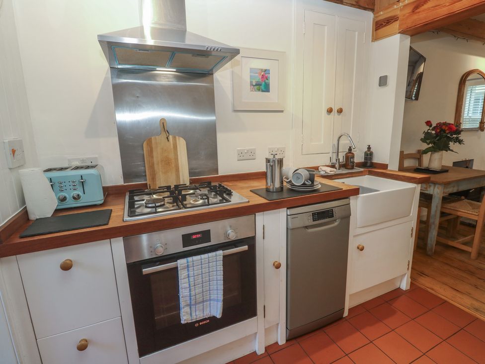 A kitchen with stove, sink, and dishwasher at Bodillys Cottage in Newlyn