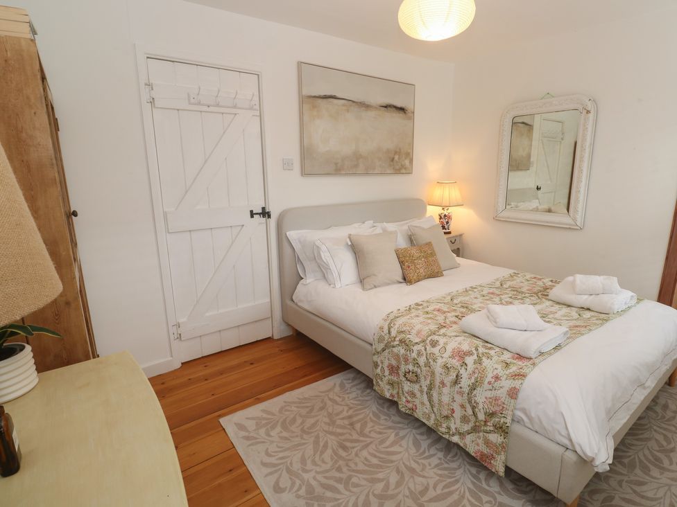 A bedroom with a bed and bedside lamp at Bodillys Cottage in Newlyn