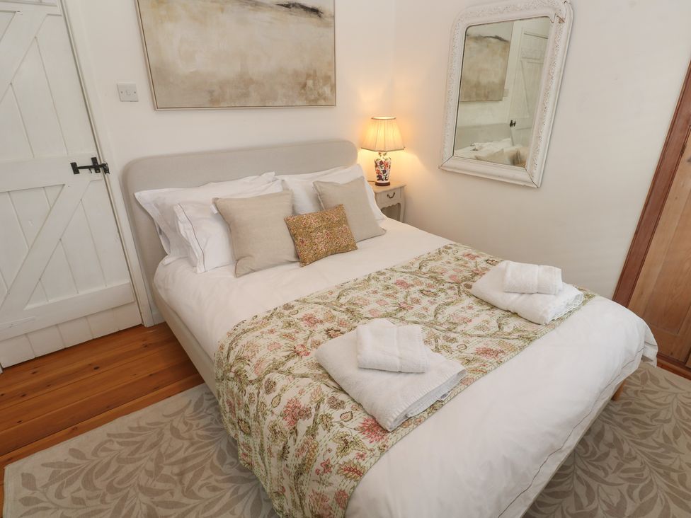 A bedroom with a bed and bedside lamp at Bodillys Cottage in Newlyn