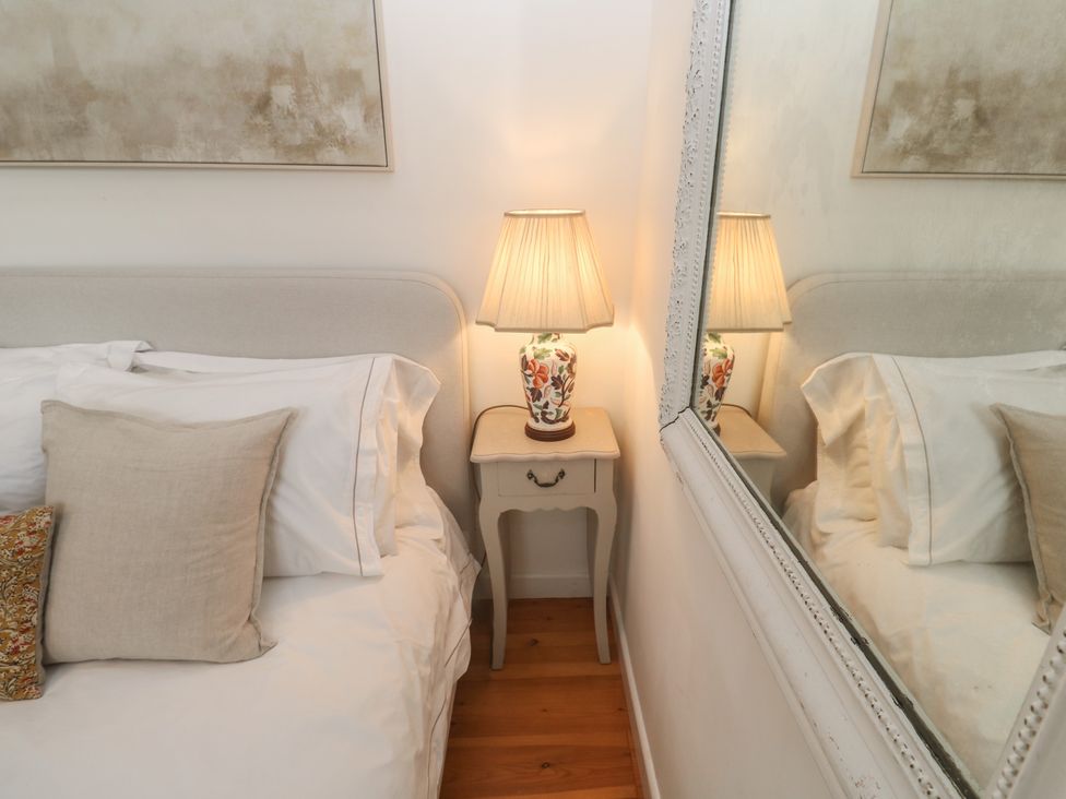 A bedroom with a bed and lamp on a nightstand at Bodillys Cottage in Newlyn