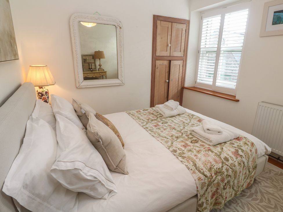 A bedroom with a bed and cupboard at Bodillys Cottage in Newlyn