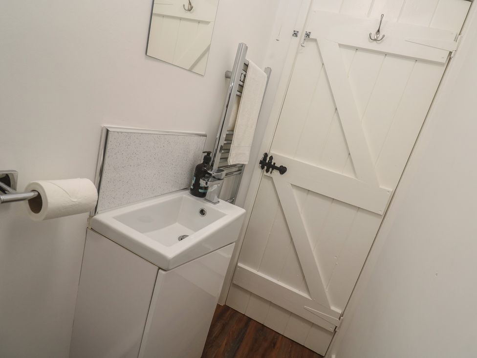 A bathroom with a sink and mirror at Bodillys Cottage in Newlyn
