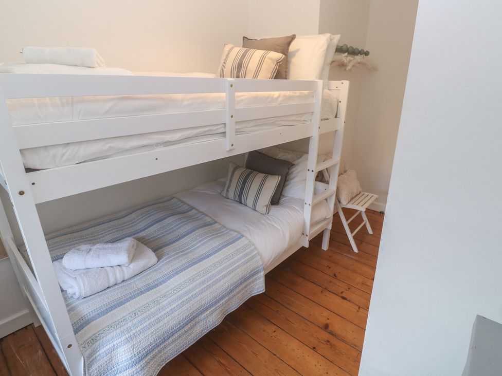 A bedroom with a bunk bed and towel at Bodillys Cottage Newlyn