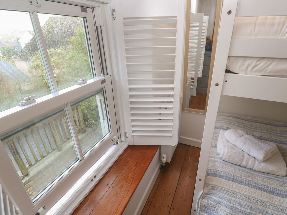A bedroom with a bunk bed and a window at Bodillys Cottage in Newlyn