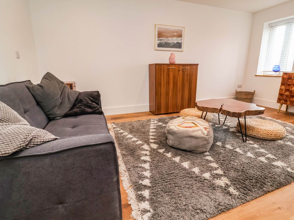 A living room with a sofa, coffee table, and rug at The Granary in Barnstaple