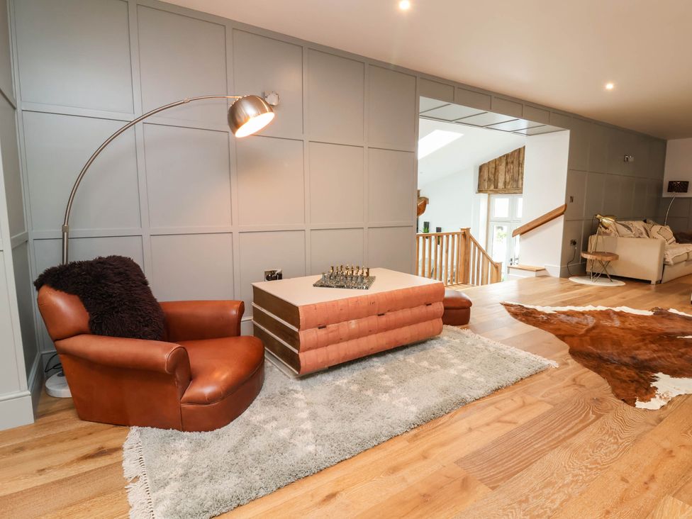 A living room with a chair, table and chess set at The Granary in Barnstaple