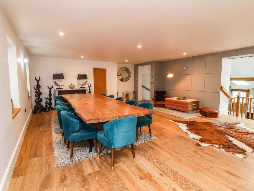 A dining room with a wooden table and teal chairs at The Granary in Barnstaple