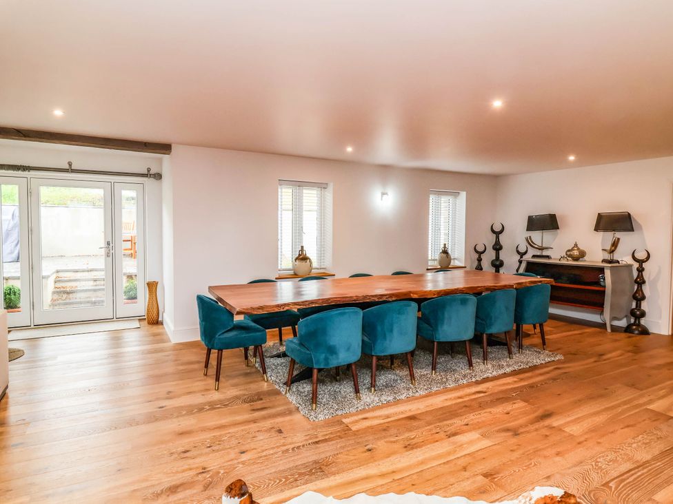 A dining room with a large table and blue chairs at The Granary in Barnstaple