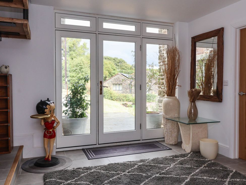 An entryway with a large front door and decorative items at The Granary in Barnstaple