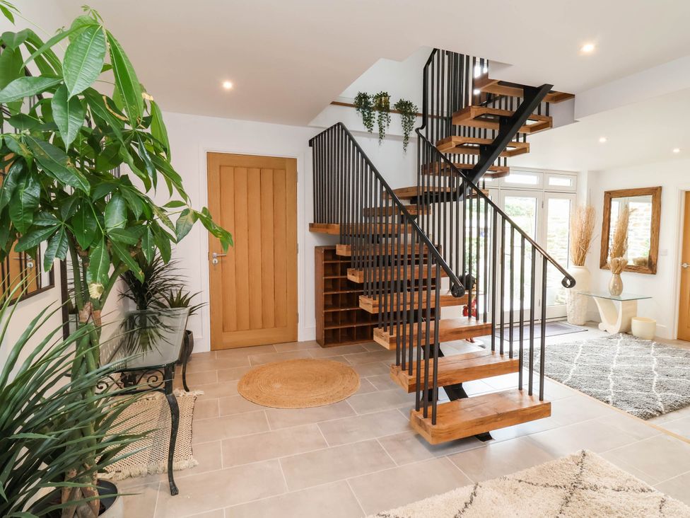 A hallway with a staircase and plants at The Granary in Barnstaple