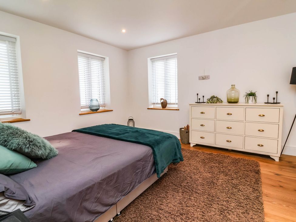A bedroom with a bed and dressing table at The Granary in Barnstaple