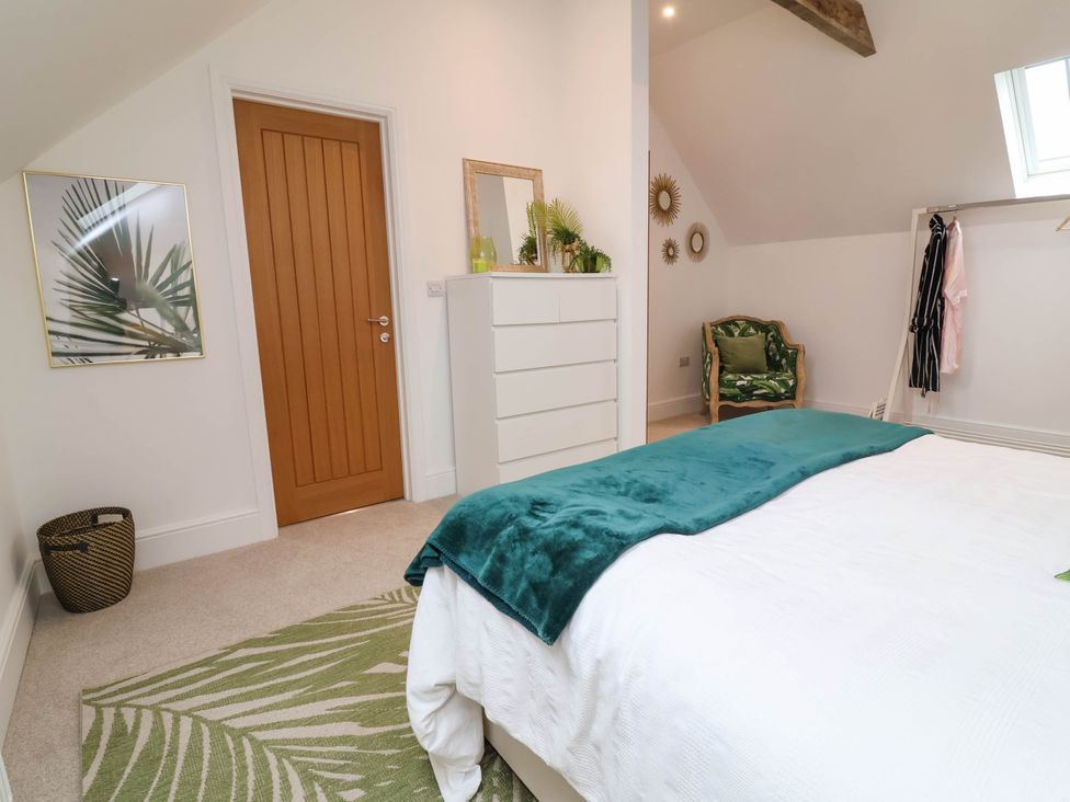 A bedroom with a bed and dresser at The Granary in Barnstaple