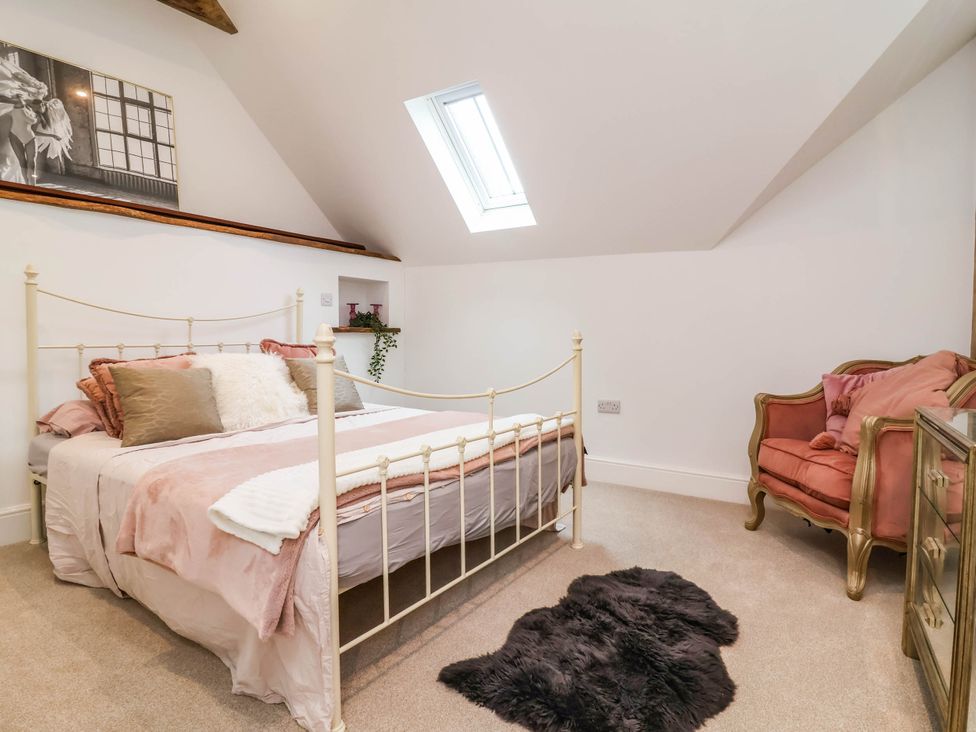 A bedroom with a bed and chair at The Granary in Barnstaple