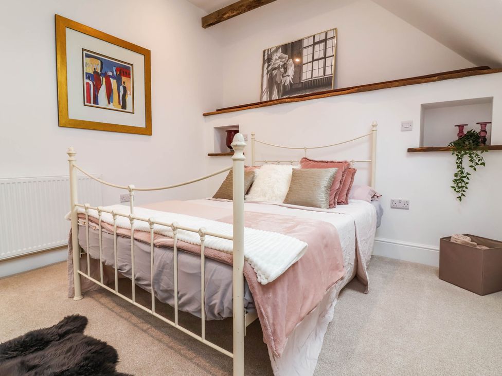 A bedroom with a bed and paintings on the wall at The Granary in Barnstaple