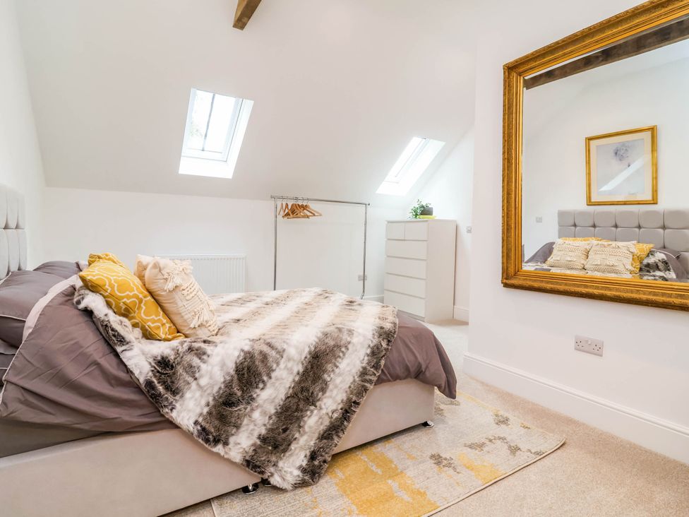 A bedroom with a bed and a dressing mirror at The Granary in Barnstaple