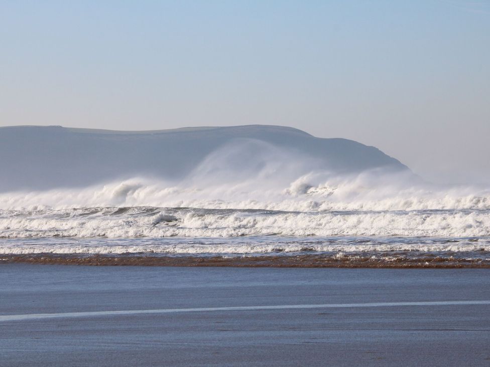 Ocean waves crashing on a beach under a clear sky at The Granary in Barnstaple