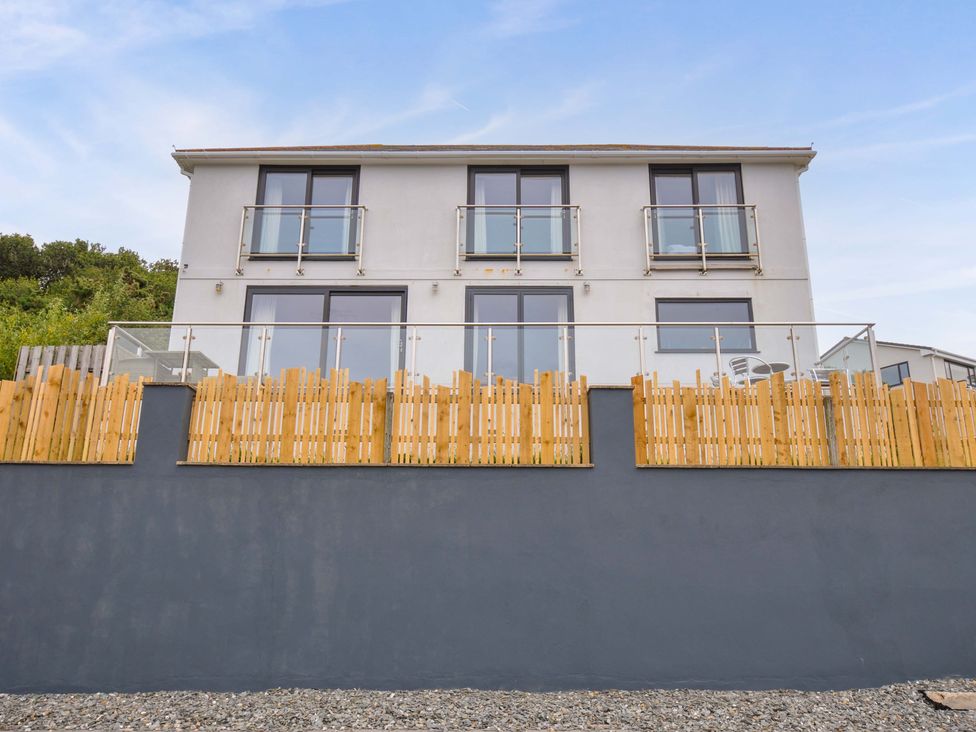 A house with balconies and wooden fencing at Looe Island View in Downderry