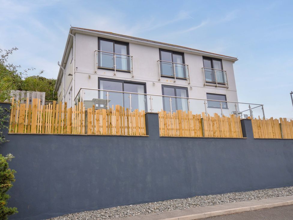 A building with a balcony and fence at Looe Island View in Downderry