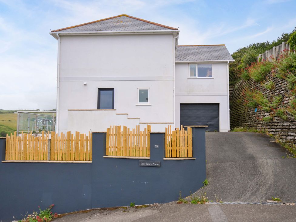 A house with a garage and fence at Looe Island View in Downderry