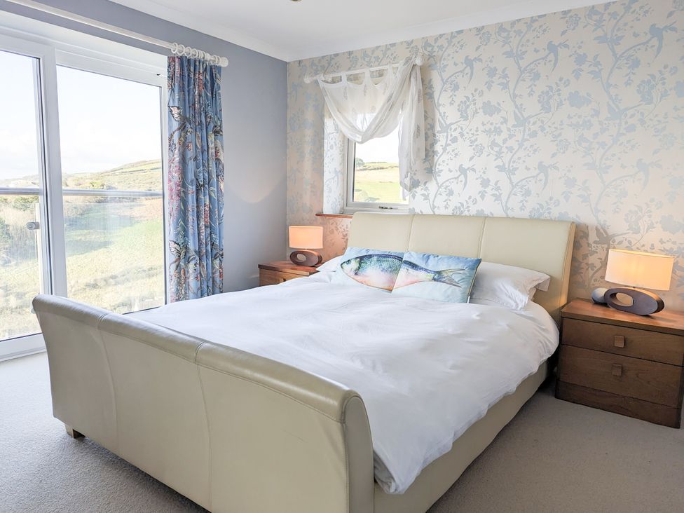 A bedroom with a bed and bedside tables at Looe Island View in Downderry