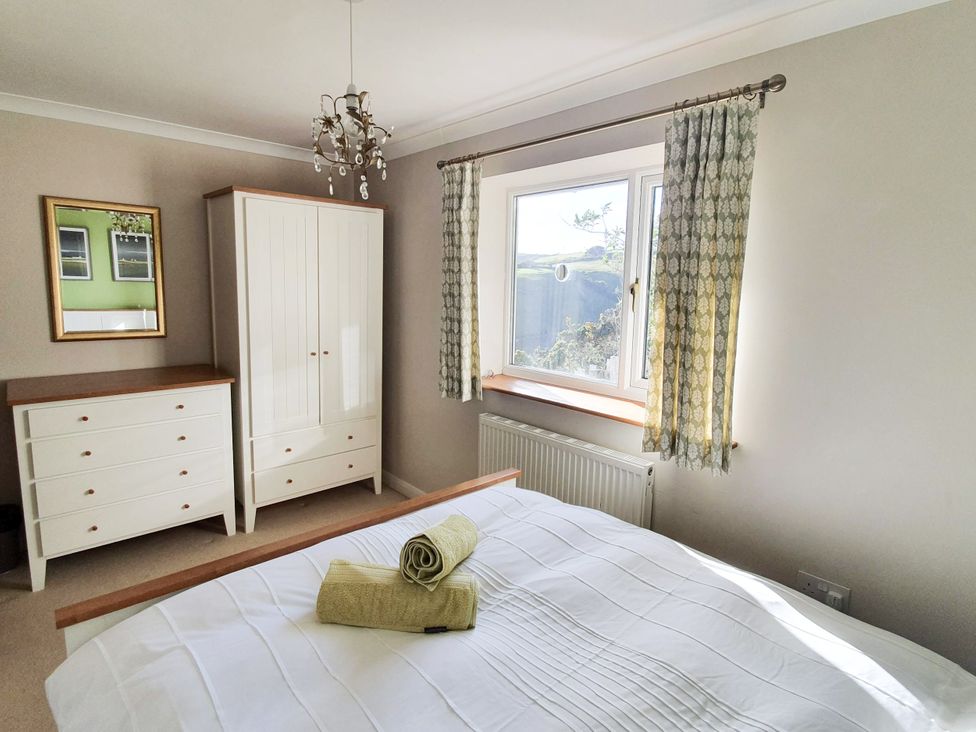 A bedroom with a bed and furniture at Looe Island View in Downderry