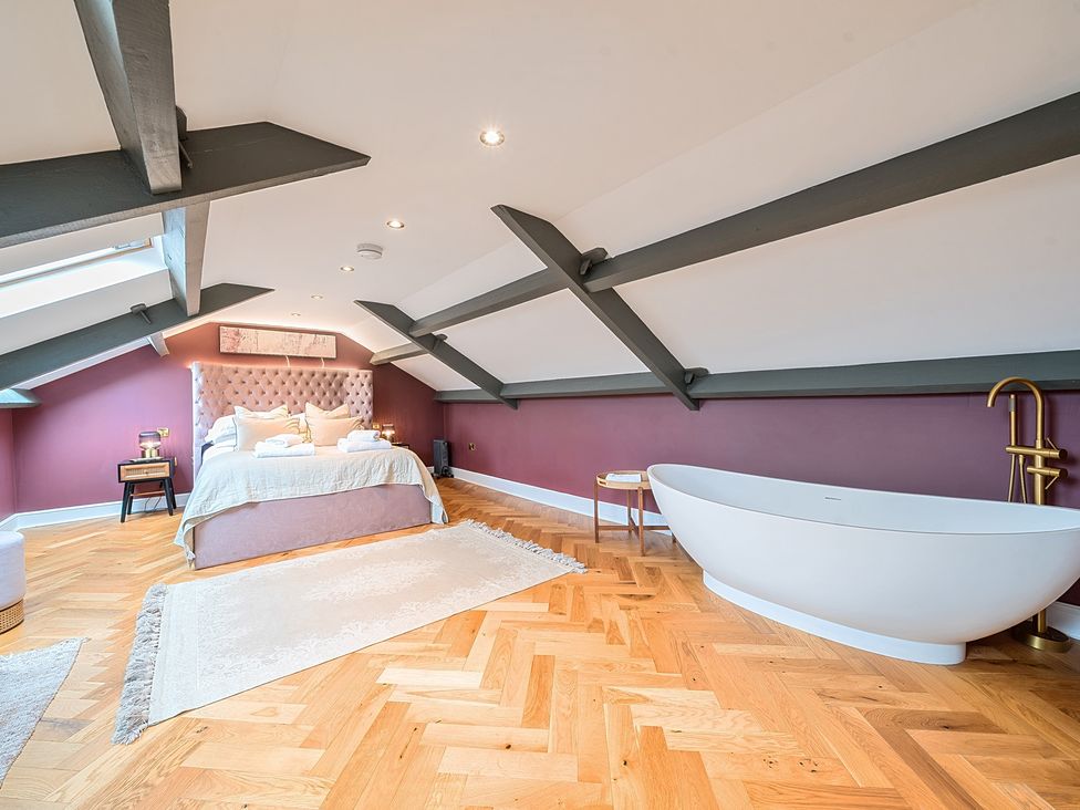 A bedroom with a bed and a bathtub at Hillside House Aysgarth near West Witton