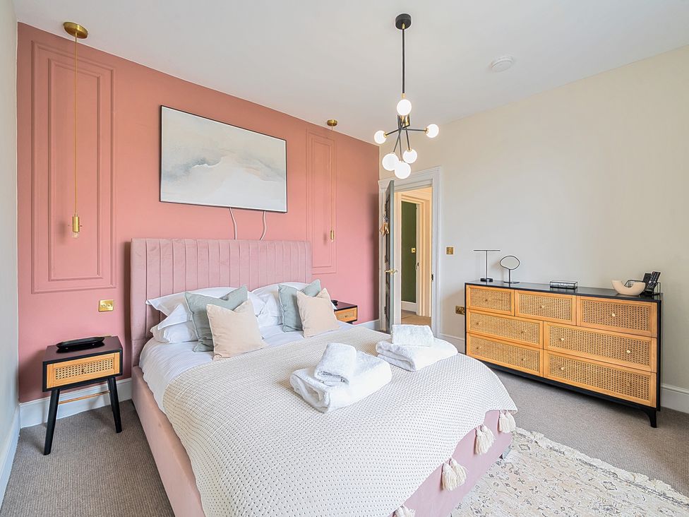 A bedroom with a pink wall and a bed at Hillside House Aysgarth near West Witton