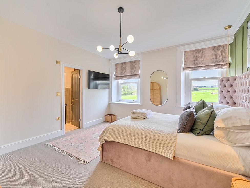 A bedroom with a bed and a mirror at Hillside House Aysgarth near West Witton