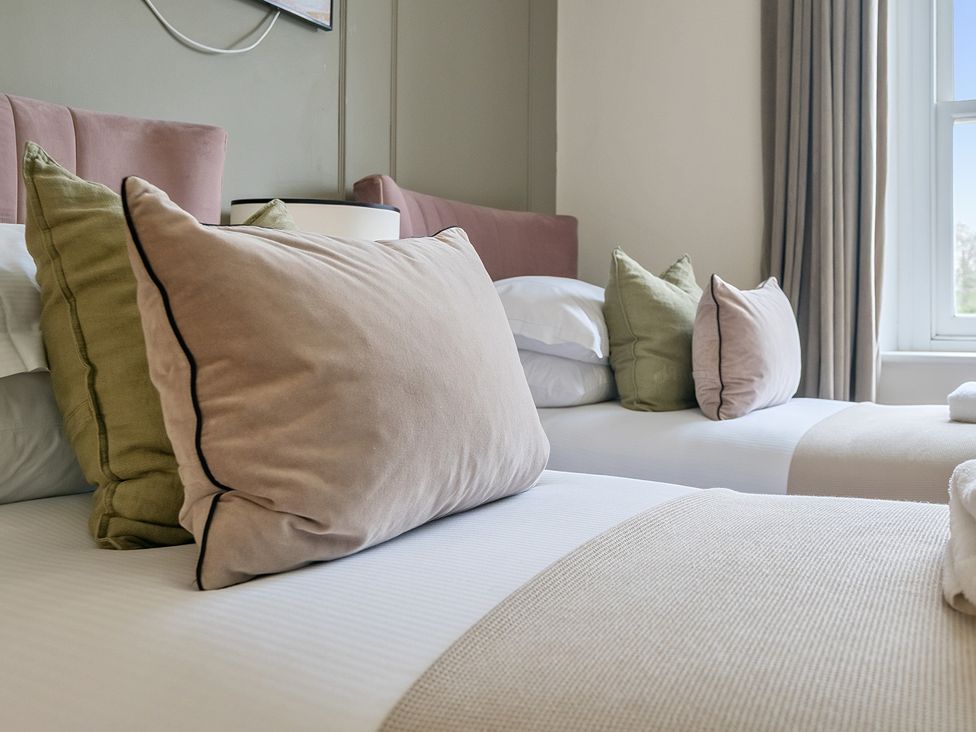 A bedroom with two beds and decorative pillows at Hillside House Aysgarth near West Witton