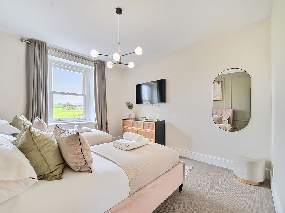 A bedroom with a bed and television at Hillside House Aysgarth near West Witton