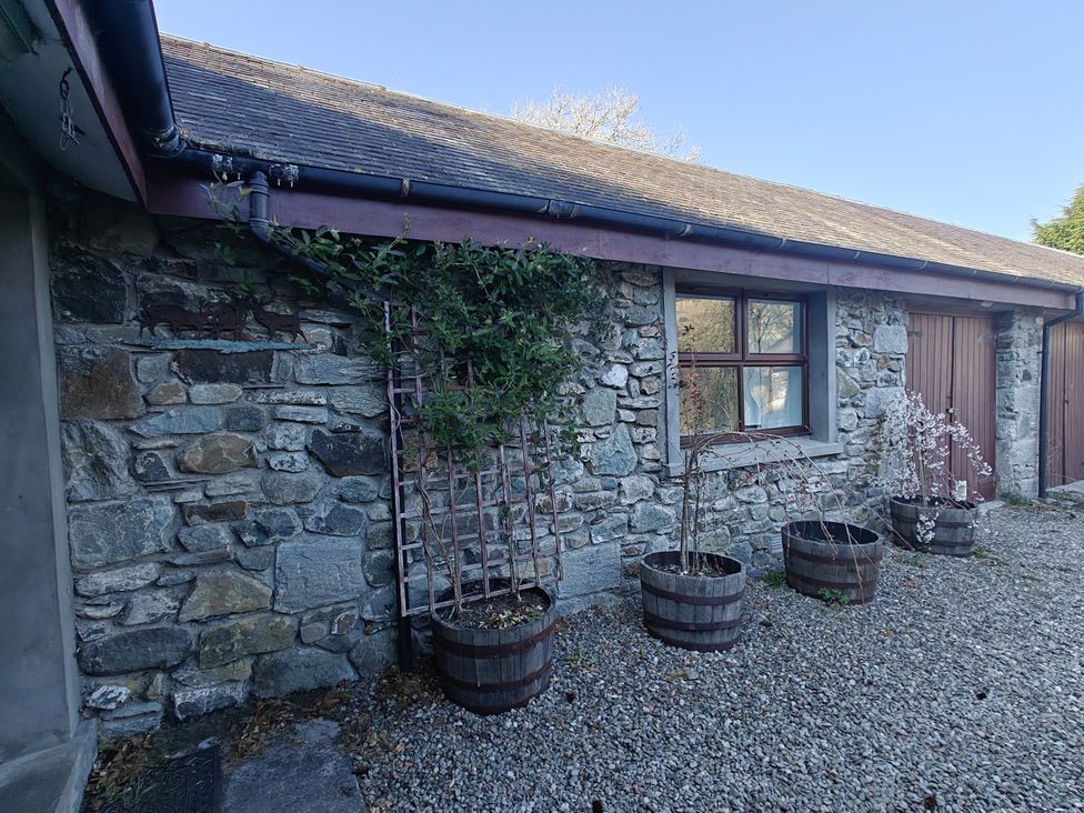 An exterior view of a stone wall with planters and a window at Ninevah in Balquhidder, Perthshire, Scotland