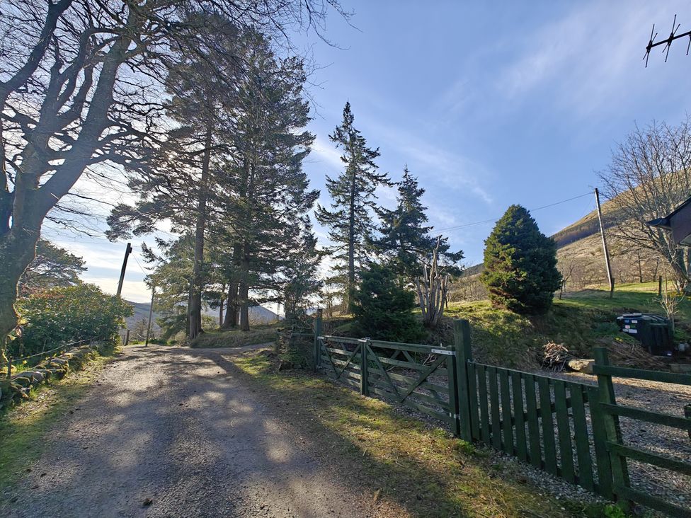 A gravel road leading through trees at Ninevah in Balquhidder, Perthshire, Scotland