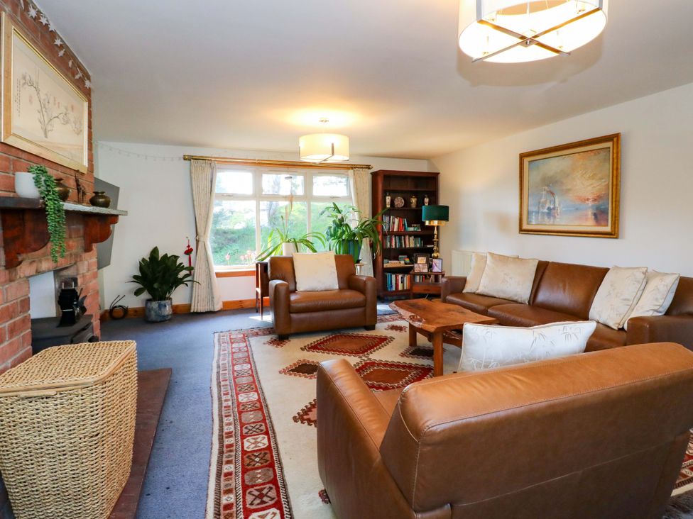 A living room with sofas and a bookshelf at Ninevah, Balquhidder, Perthshire, Scotland