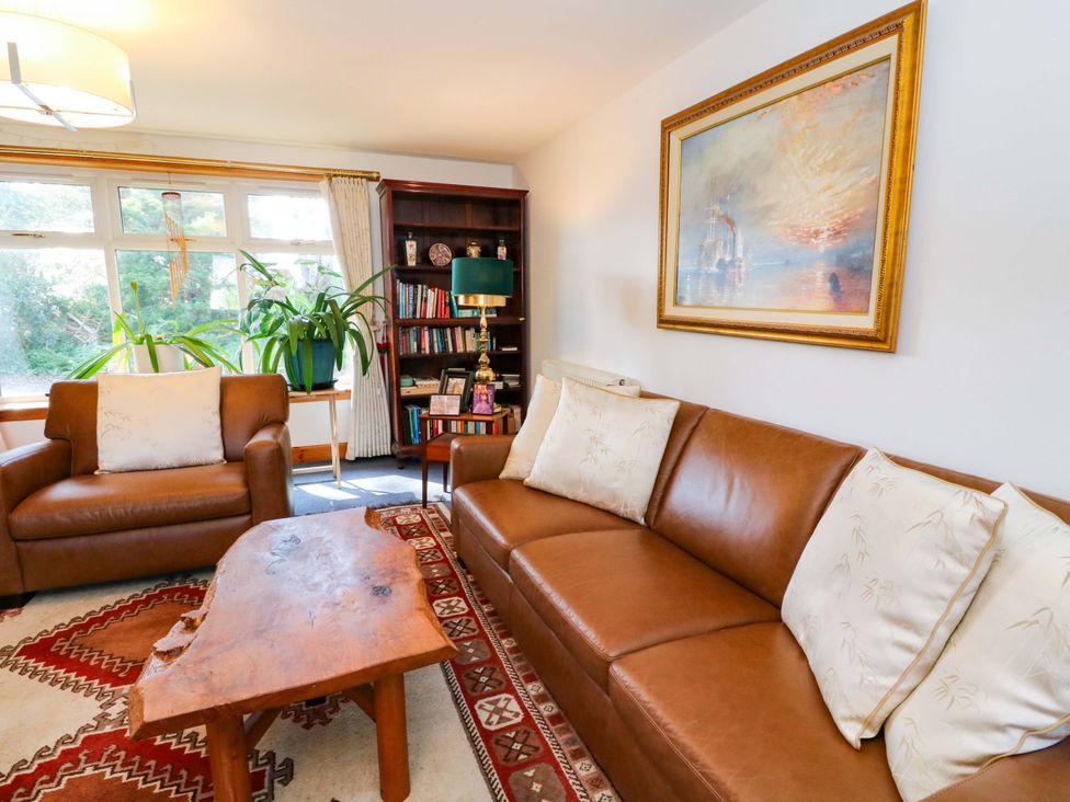 A living room with a brown sofa and armchairs at Ninevah, Balquhidder, Perthshire, Scotland