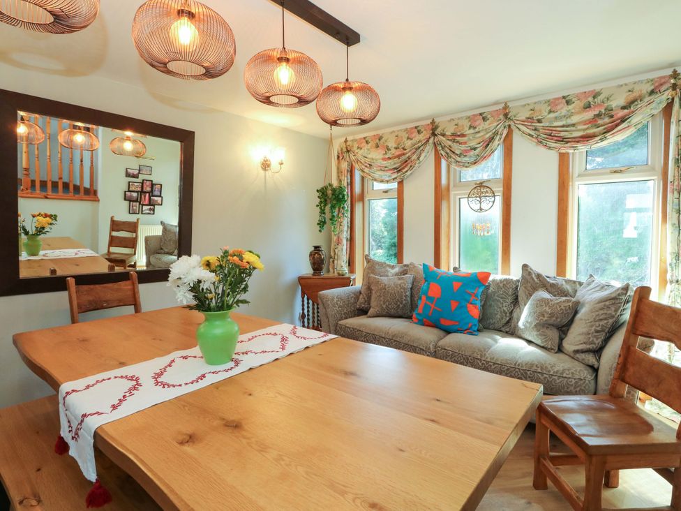 A dining room with a table and sofa at Ninevah, Balquhidder, Perthshire, Scotland