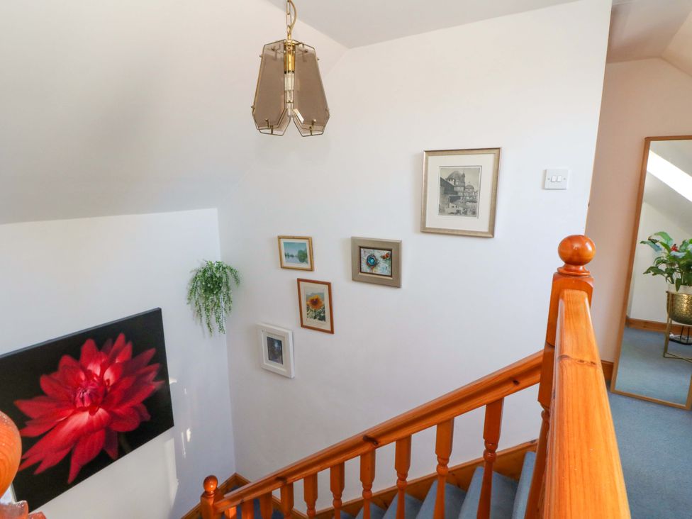 A staircase with wall art and a light fixture at Ninevah in Balquhidder, Perthshire, Scotland