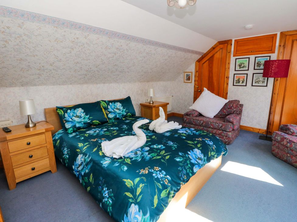 A bedroom with a bed and seating area at Ninevah in Balquhidder, Perthshire, Scotland