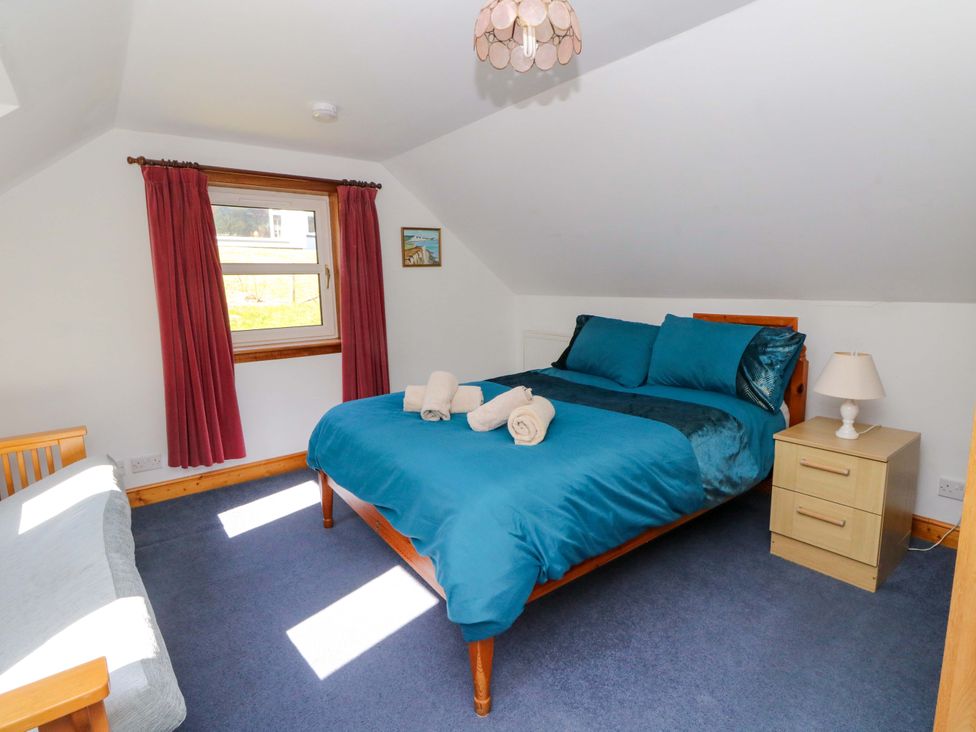 A bedroom with a bed and side table at Ninevah in Balquhidder, Perthshire, Scotland