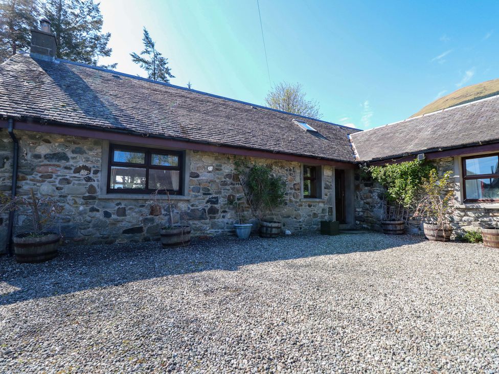 A stone cottage exterior with windows and plant pots at Ninevah, Balquhidder, Perthshire, Scotland