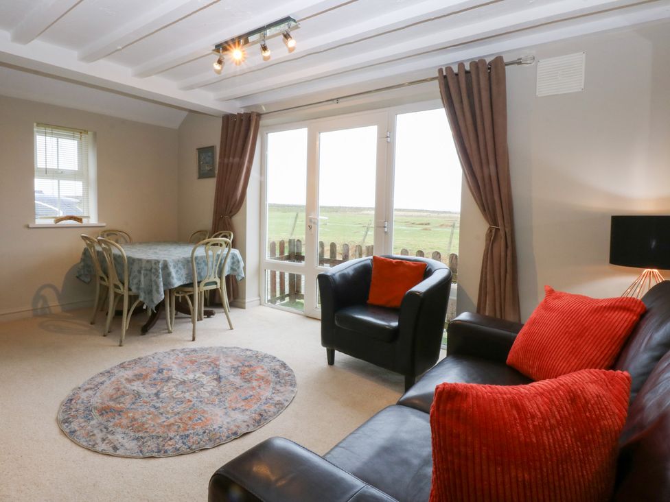 A living room with a table and chairs at Oak Cottage Dinas Dinlle near Caernarfon