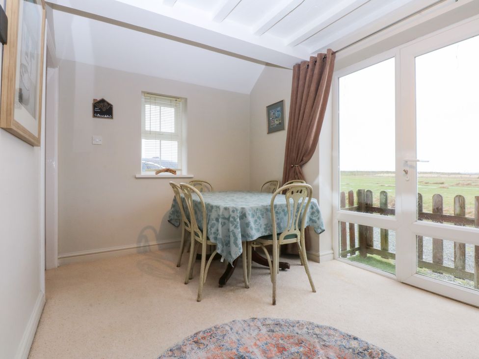A dining room with a table and chairs at Oak Cottage Dinas Dinlle near Caernarfon