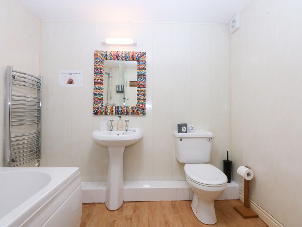 A bathroom with a sink, toilet, and bathtub at Oak Cottage in Dinas Dinlle near Caernarfon